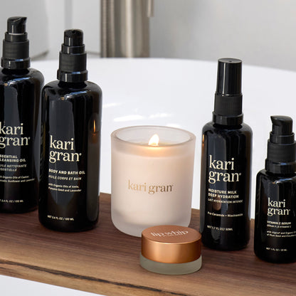 Kari Gran skincare and candle products on a wooden shelf.