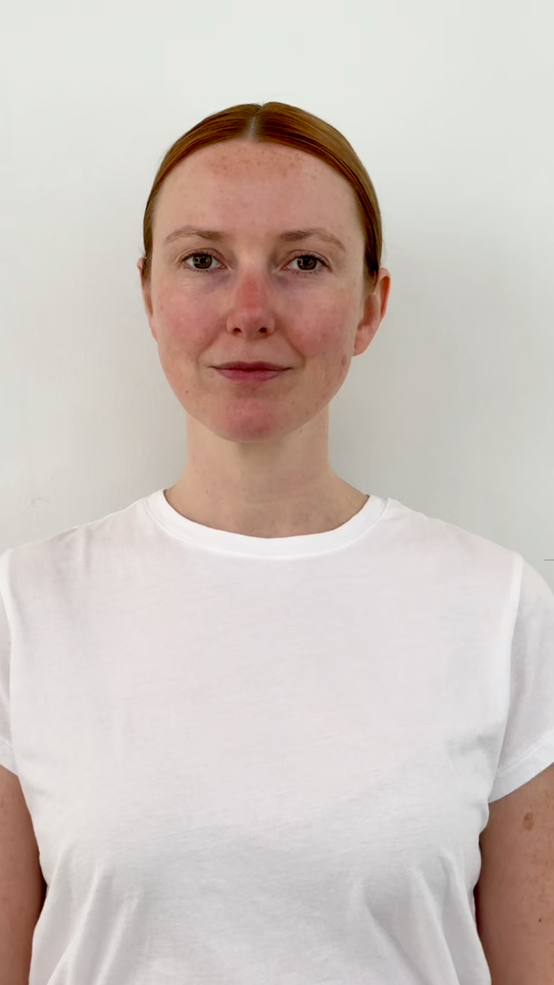 Person wearing a white t-shirt against a plain background