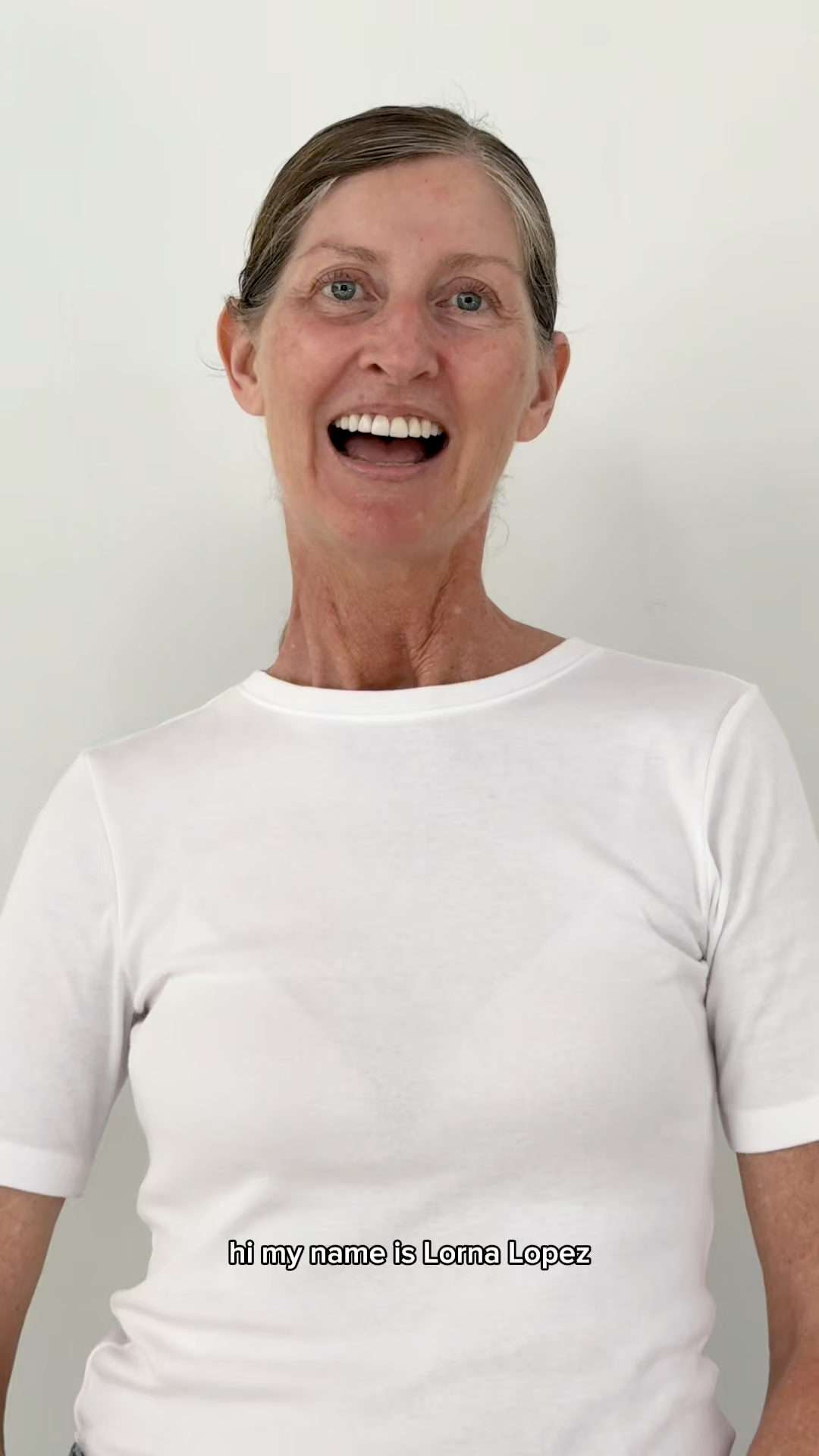 Person wearing a white t-shirt with 'Hi my name is Lorna Lopez' text on a plain background
